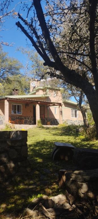 a house with a tree in front of it at Chalet del Rio in Cuesta Blanca