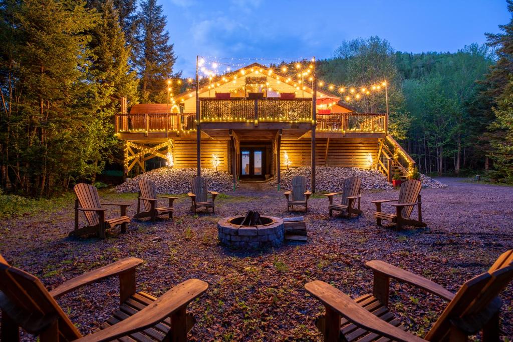 a log cabin with chairs and a fire pit at Ask us for our immersive 3D virtual tour before reservation in Lac-Superieur