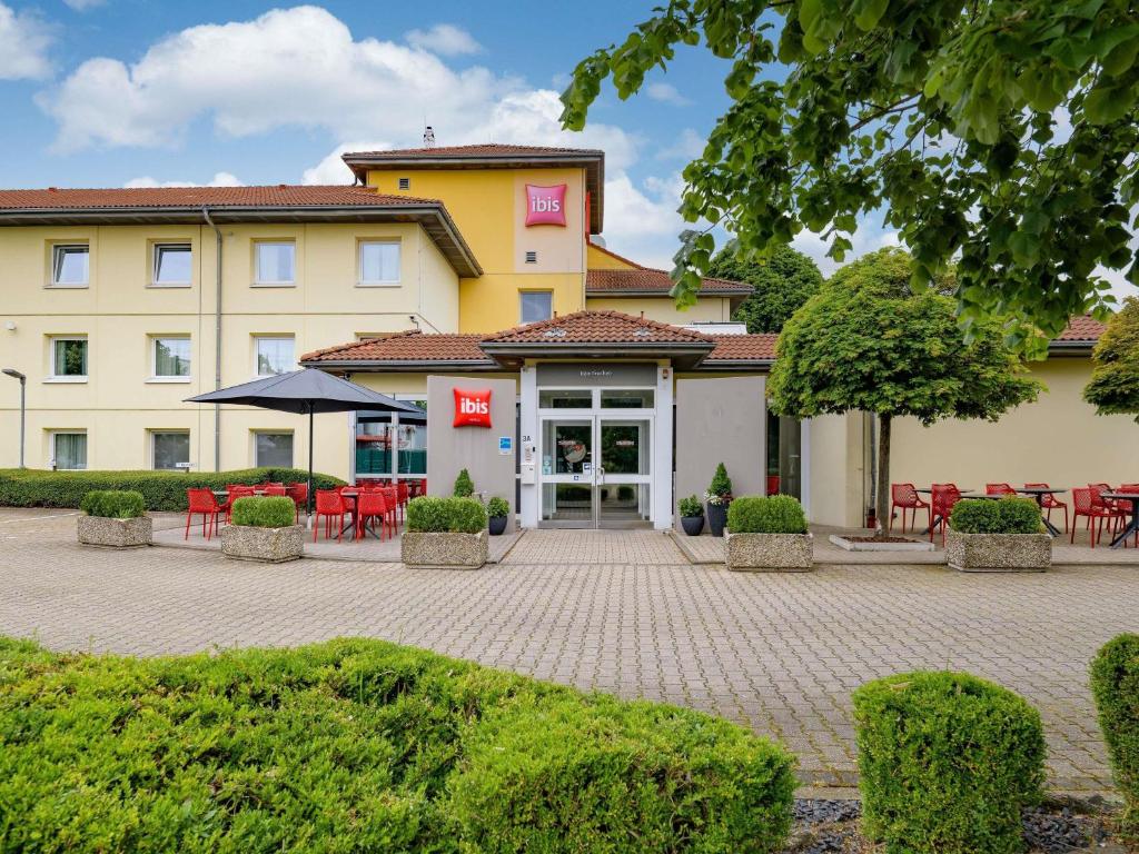 a hotel with tables and chairs in a courtyard at ibis Köln Frechen in Cologne