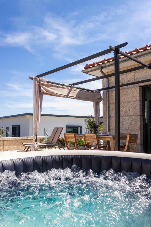 a pool with a pergola and chairs and a swimming pool at Quinta do Olival Amarante in Gatão