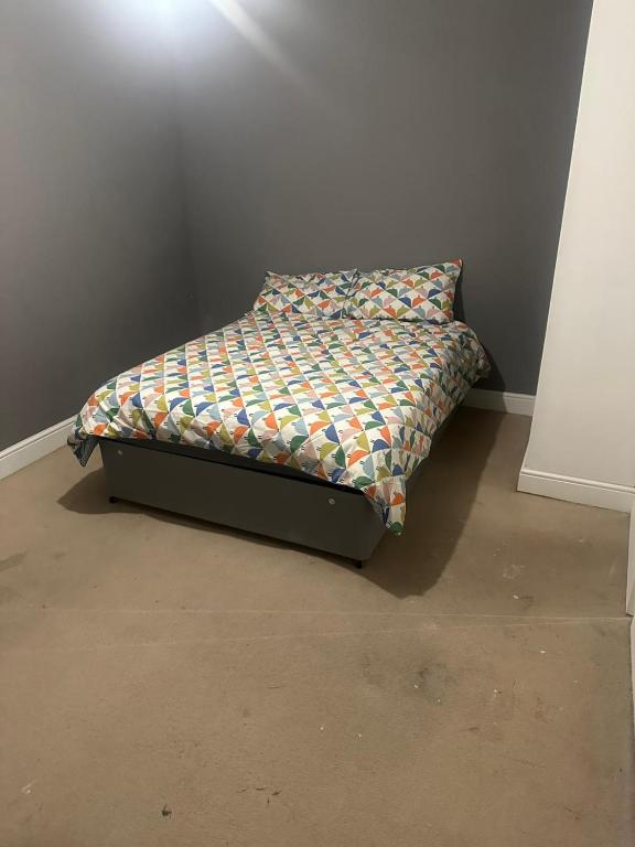 a bed sitting in a corner of a room at Ramsgate Cozy Home in Ramsgate