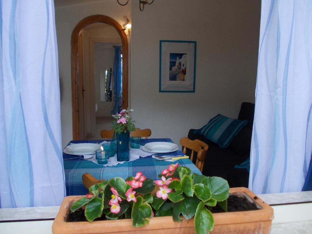 a table with a blue table cloth and flowers on it at Villetta Lucia in Sperlonga