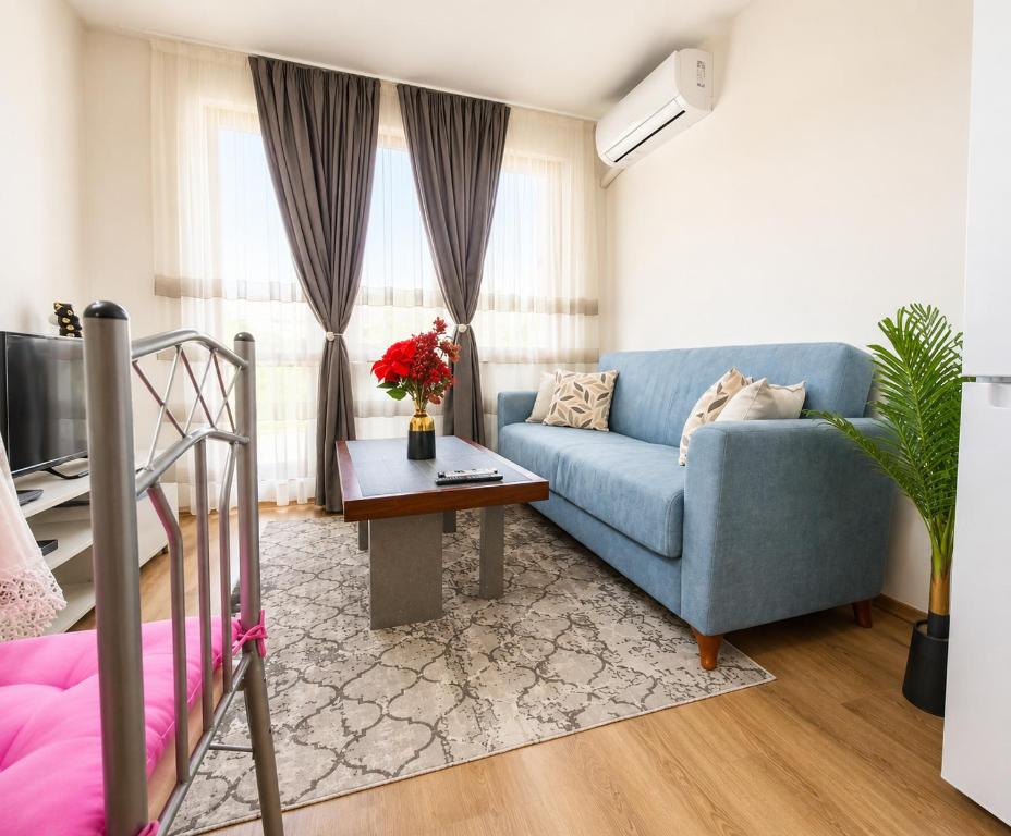 a living room with a blue couch and a table at Diamond Heights apartament in Bansko