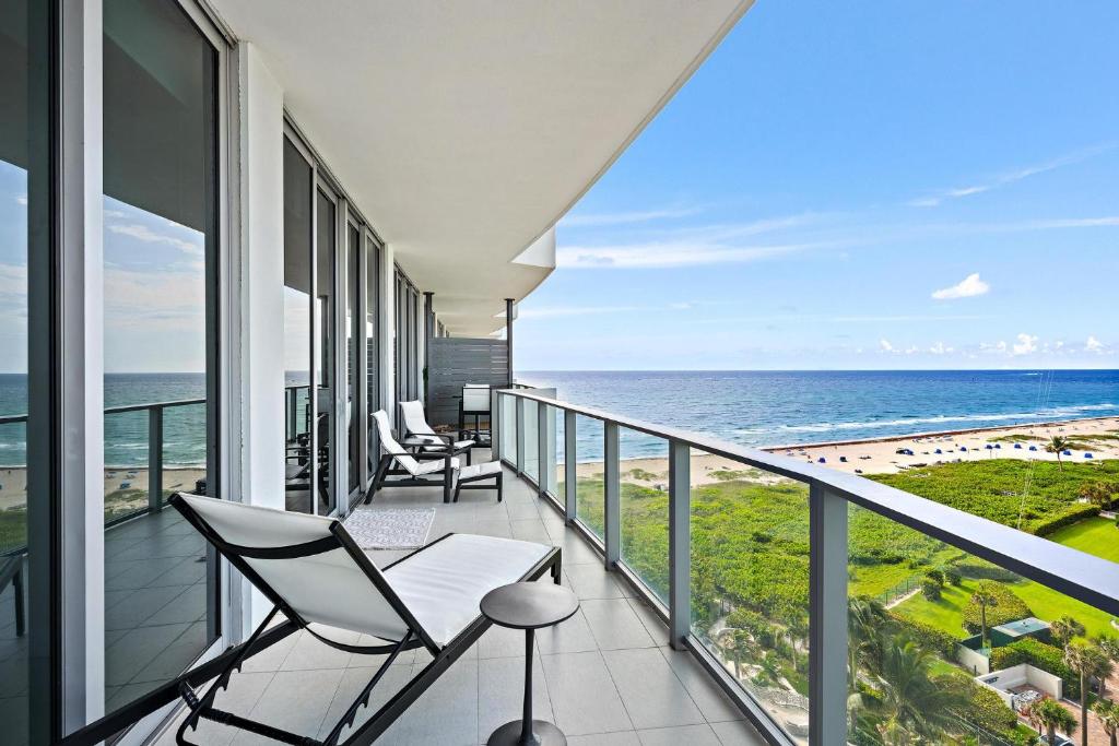 a balcony with chairs and a view of the beach at Amrit Resort - Bask in Rare Oceanfront Luxury with Stunning Views in Riviera Beach