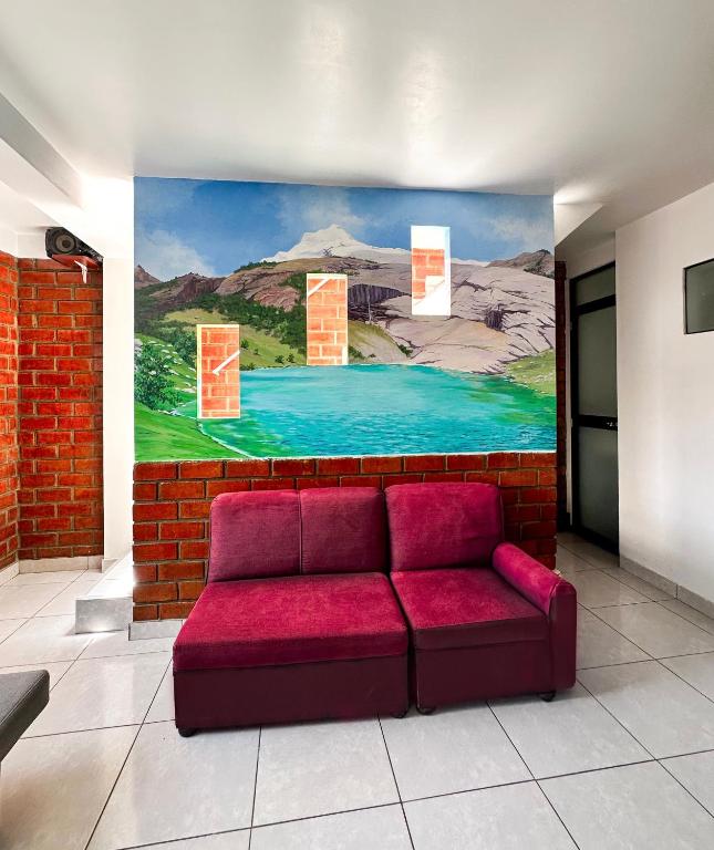 a red couch in a room with a painting on the wall at Munay Wasy Carhuaz in Carhuaz