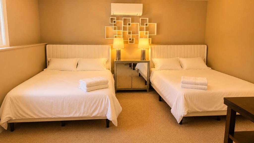 a room with two beds and a table at Private Two Queen Beds Room Near UPEI & Downtown Cozy Retreat Near Everything in Charlottetown