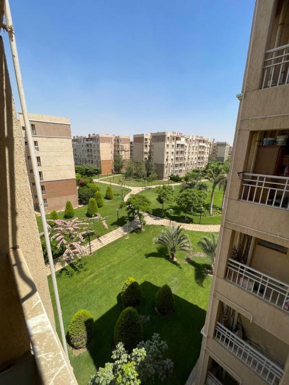 a view of a park in a city with buildings at شقه في مدينتي غرفتين و صاله مكيفه مفروشه فندقي - Fully Furnished & Air-Conditioned 2-Bedroom Apartment with Large Living Room in Madinaty - 98 sqm in Madinaty