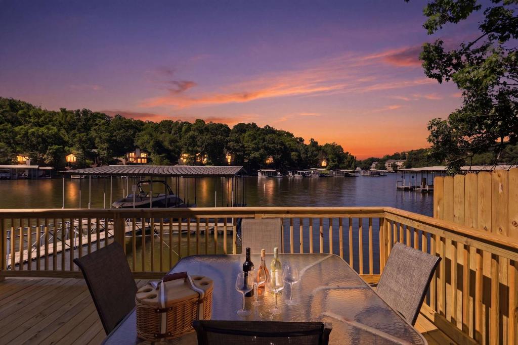 a table with bottles of wine sitting on a deck at Private Dock-Deck-LakeHouse-Lake Front-3bd 2bth in Lake Ozark
