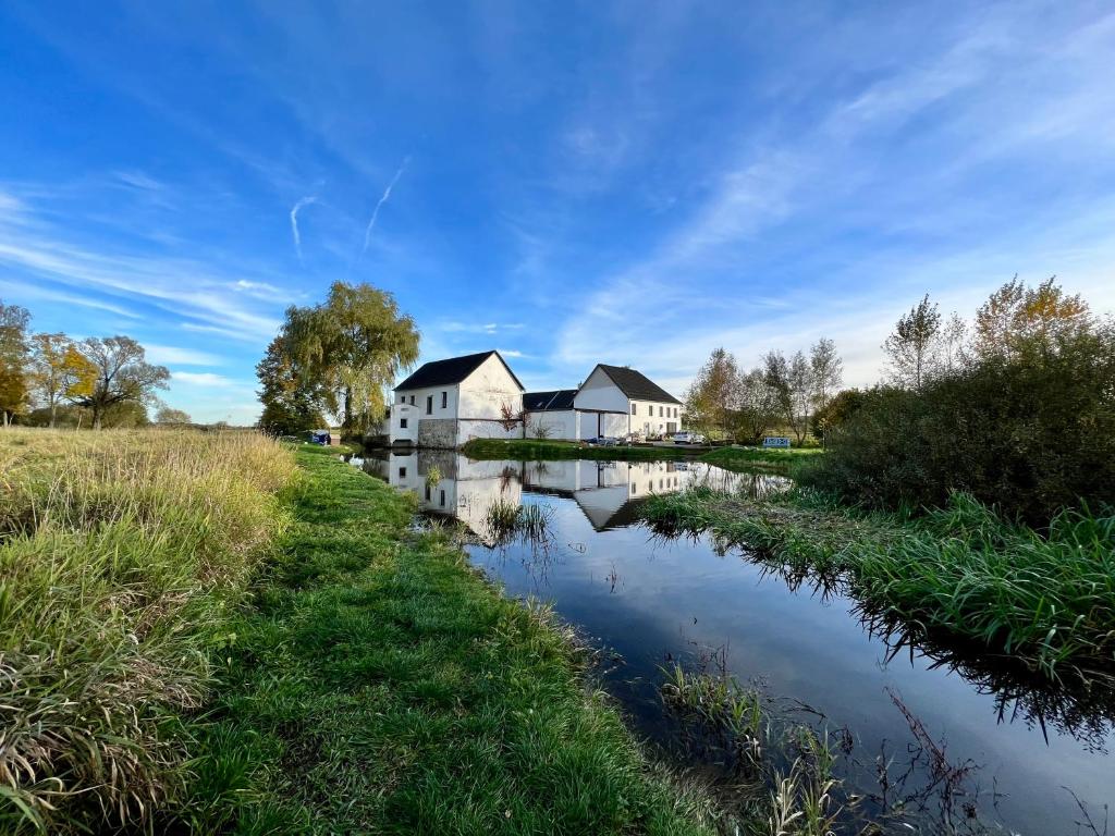 a house next to a river with buildings at The Sanctuary with private Jacuzzi in České Budějovice