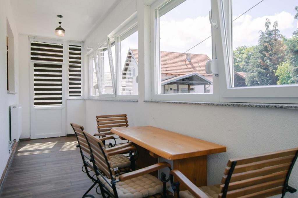 a porch with a wooden table and chairs and windows at Apartment Smoljanac 14979b in Smoljanac