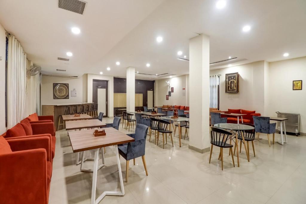 a dining room with tables and chairs in a restaurant at Capital O Divira Inn in Dhanbād