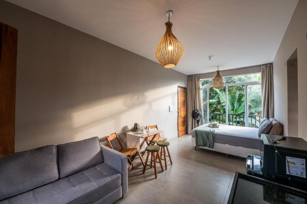 a living room with a couch and a bed at Casa Jabu in Catas Altas