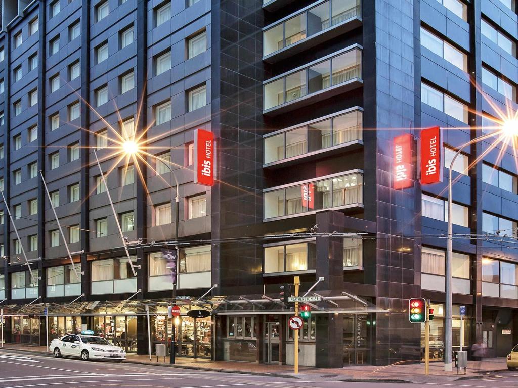 a building with red signs on the side of it at ibis Wellington in Wellington