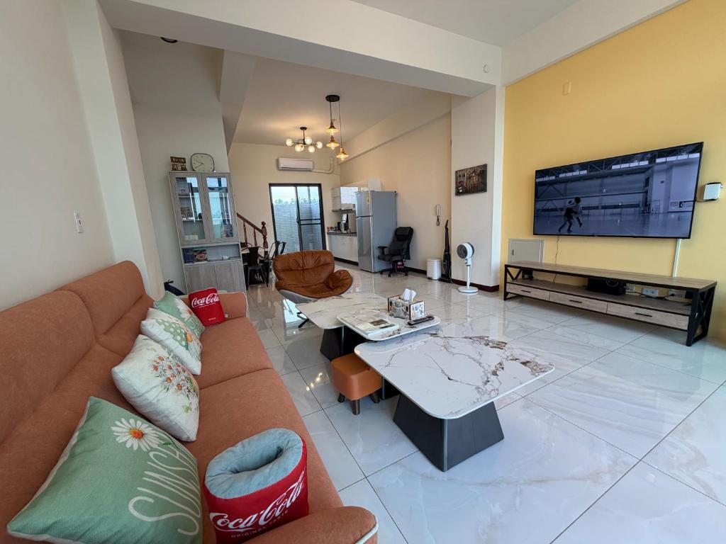 a living room with a couch and a tv at 捌之捌民宿 in Nan-ho-ts'un