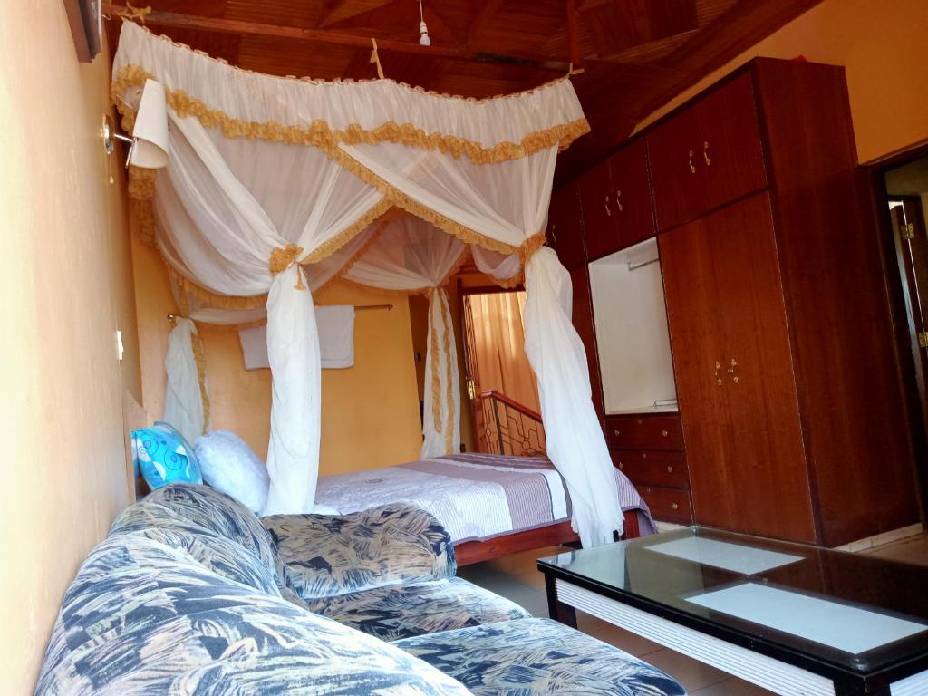 a bedroom with a bed and a couch and a table at Scenic View Hotel and Resort in Thika