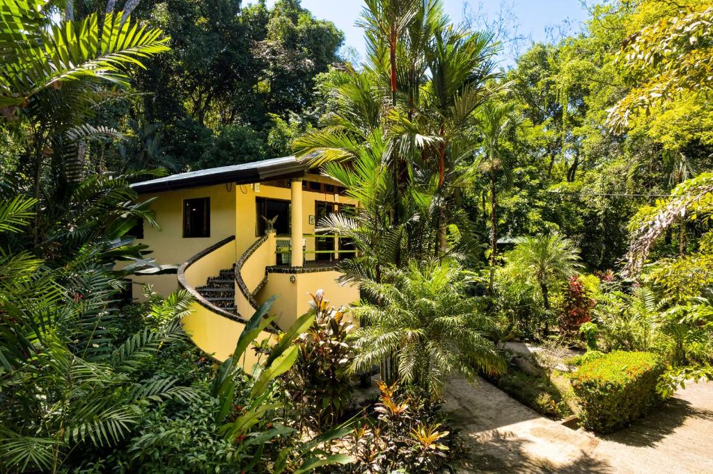 a yellow house in the middle of a forest at Casa Selva in Dominicalito