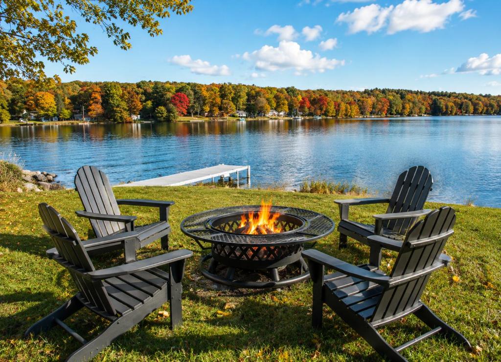 three chairs around a fire pit next to a lake at Lakefront Retreat Home- Swimming-Fishing-Boating in Bethlehem