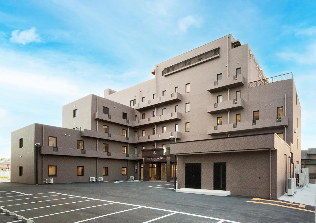 a building with a parking lot in front of it at The Kato Hotel in Tokai