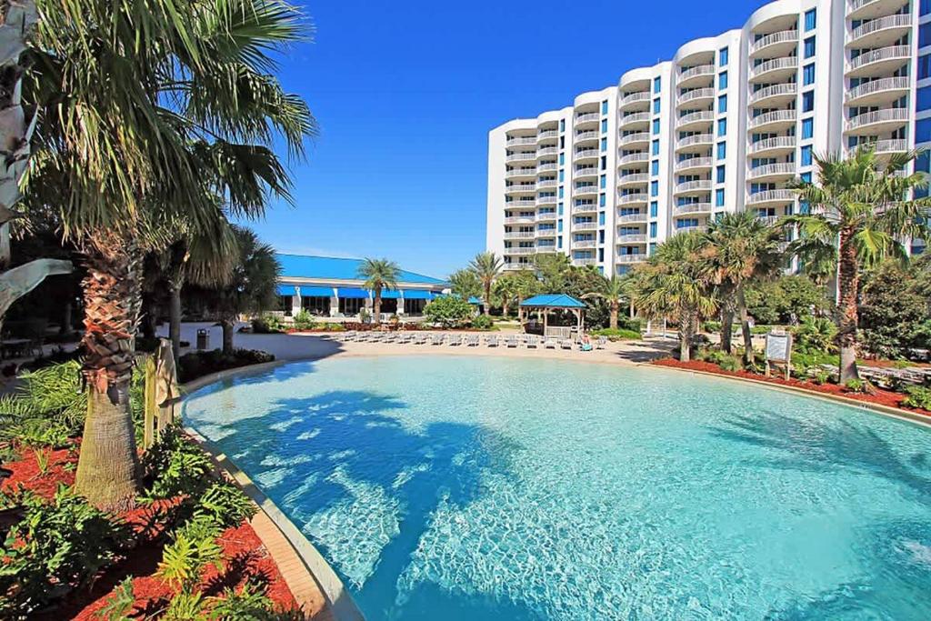 a large swimming pool in front of a large building at A Wave From it All in Destin