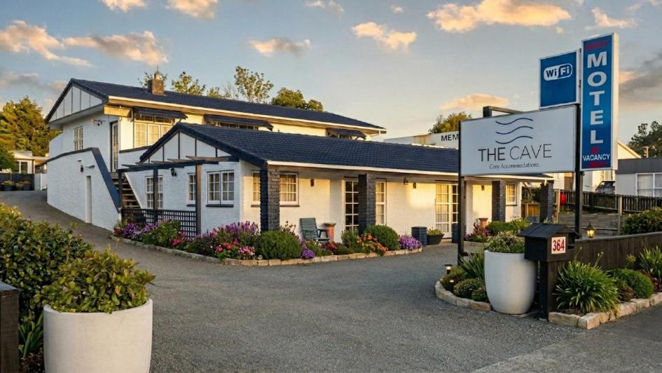 a white building with a sign in front of it at The Cave Motel in Levin