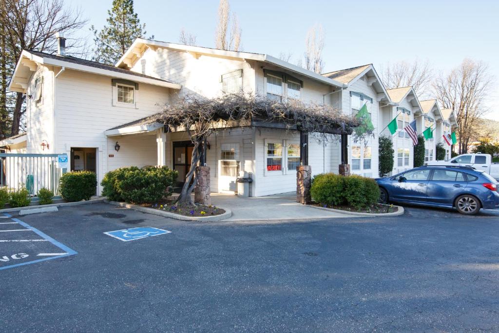 a car parked in a parking lot in front of a house at Murphys Inn Motel in Murphys