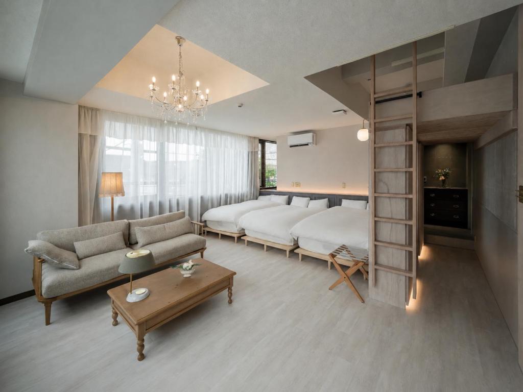 a living room with two beds and a couch at ホテル寺町亘hotel teramachi watari in Matsue