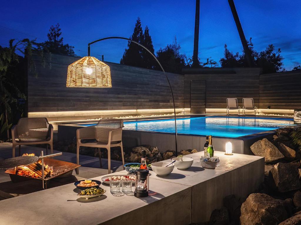 a table with food on it next to a swimming pool at LANDFORM workshop cottage KEIHOKU in Kyoto