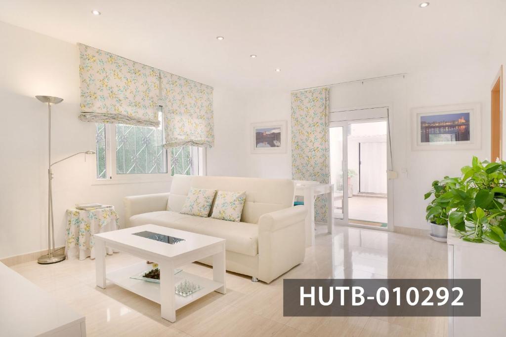 a white living room with a couch and a table at Apartamento Roca Mar in Sitges