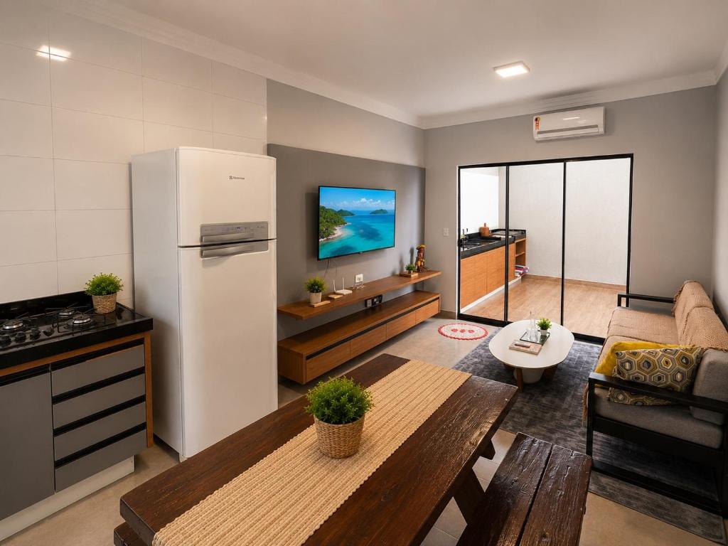a kitchen and living room with a refrigerator and a table at Conforto e praticidade em um só local in Rio Verde