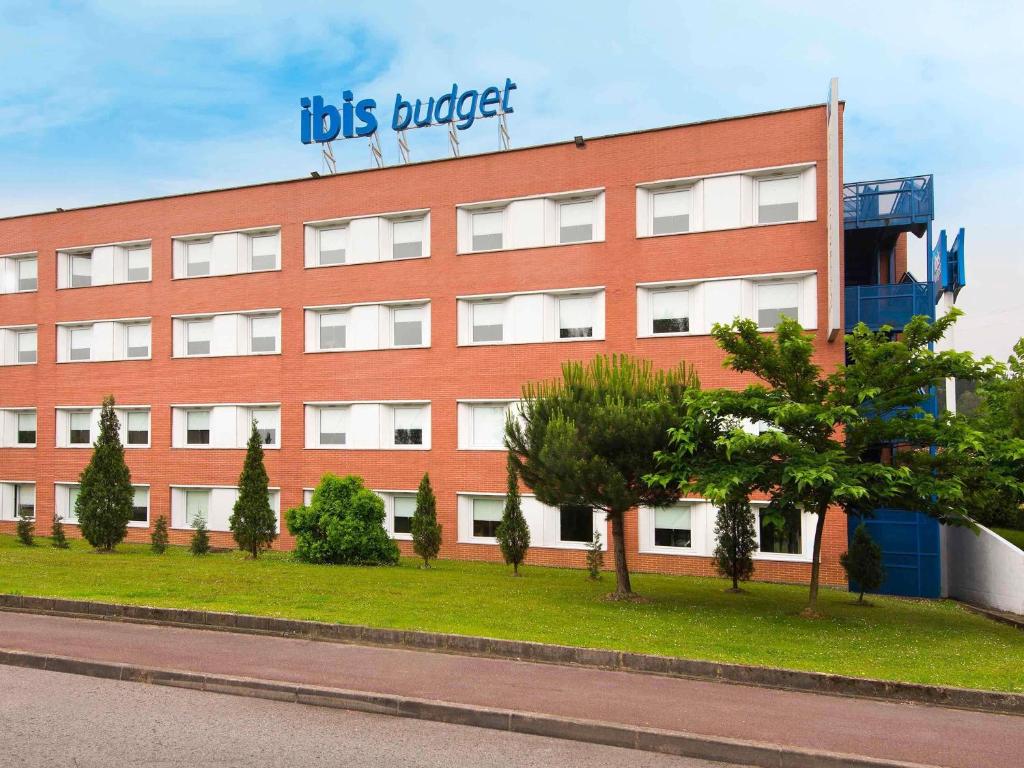 a red building with a sign on top of it at Ibis Budget Bilbao Arrigorriaga in Arrigorriaga