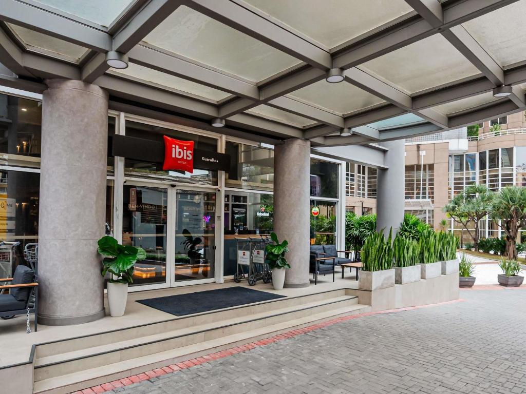 a store front of a building with potted plants at ibis Guarulhos Aeroporto in Guarulhos