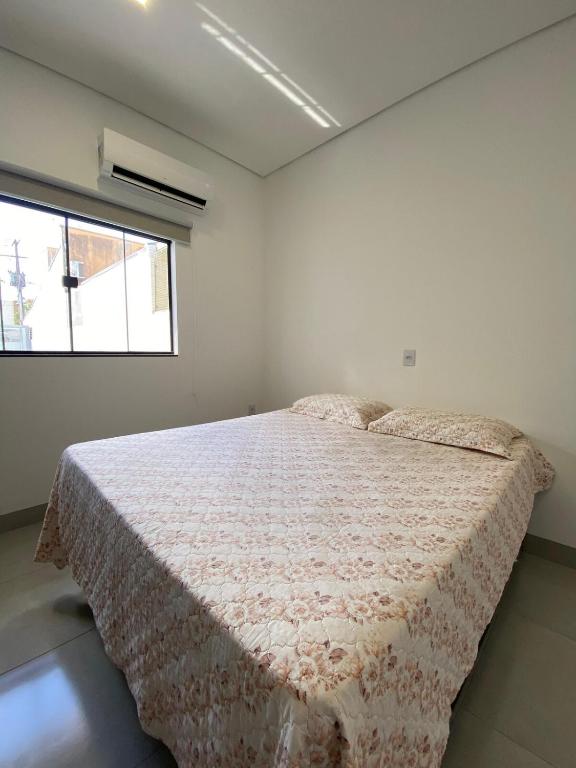 a bedroom with a bed and a window at Lindo APTO bem localizado em Sinop! in Sinop