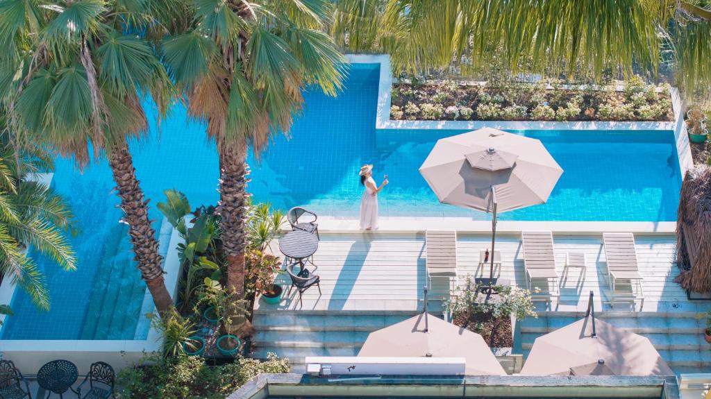 a woman standing in a pool with an umbrella at Silver Beach Yuese Hostel in Beihai