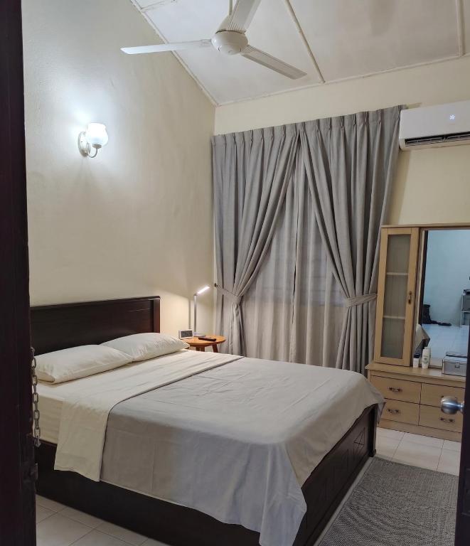 a bedroom with a large bed and a window at Econo Homestay in Ipoh