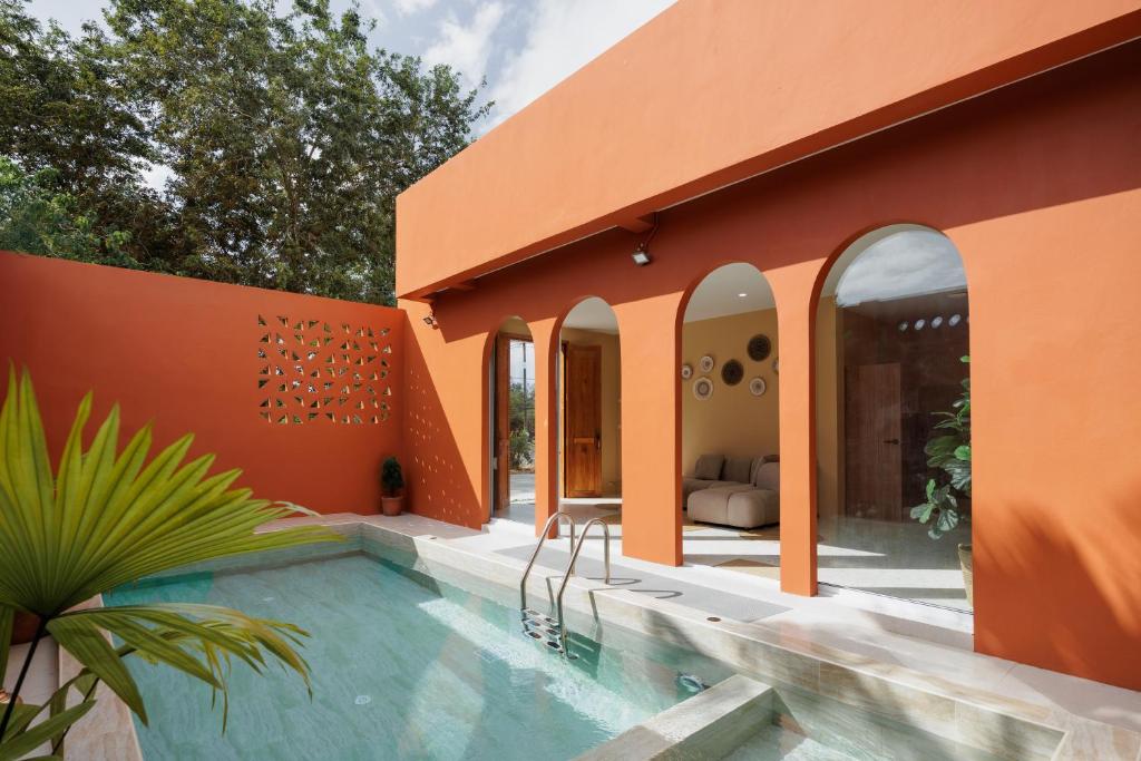 an orange house with a swimming pool at เพลาวิลล่า in Langu