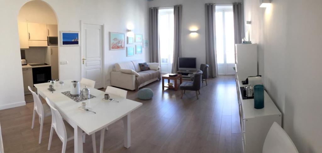 a kitchen and living room with a white table and chairs at 2 Bedrooms Appartement In Central Location on the famous Place Massena Nice in Nice