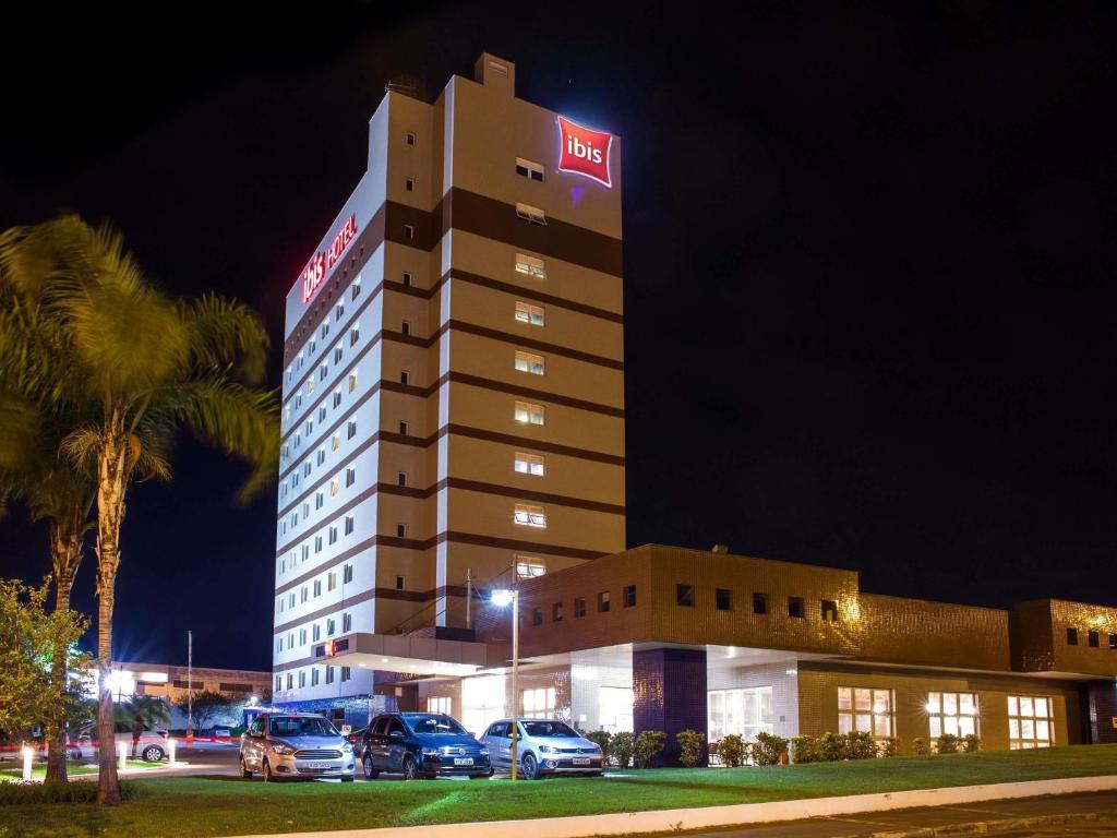 a hotel building with cars parked in front of it at ibis Araçatuba in Araçatuba