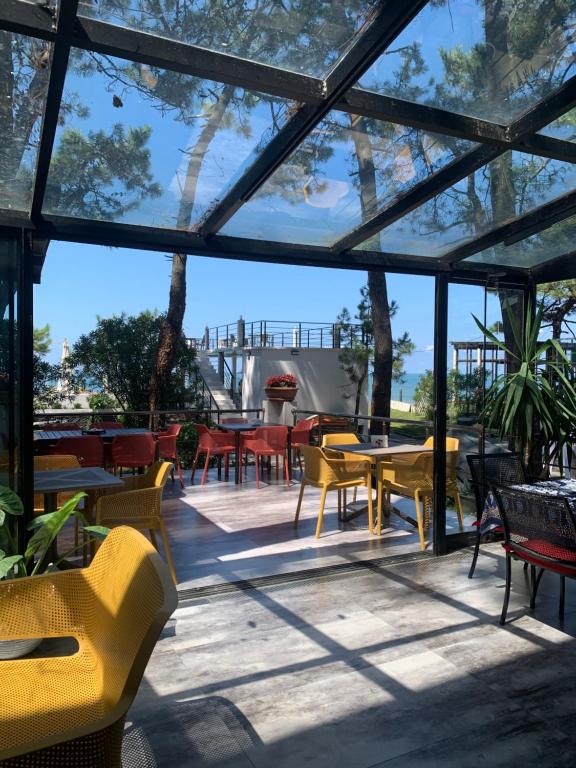 eine Terrasse mit gelben Stühlen und Tischen in der Unterkunft Mana-Mana in Grigoleti