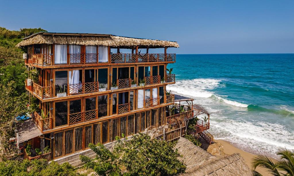 a building on the beach next to the ocean at Jaguar Beachfront Ecohotel & Spa in Santa Marta