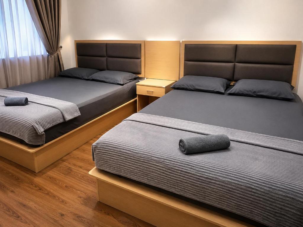 two beds in a room with two beds sidx sidx sidx at Homestay Murah Lahad Datu in Lahad Datu