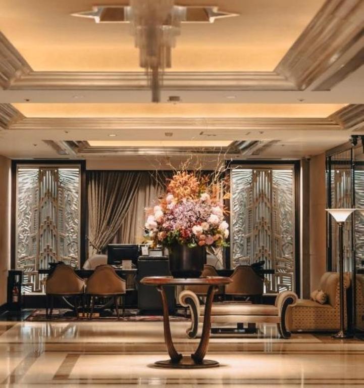 a lobby with a table with a vase of flowers at The Landis Taipei in Taipei