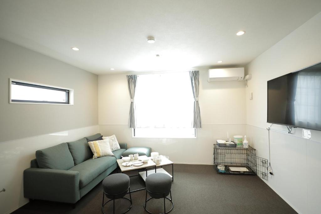 a living room with a couch and a tv at Casa Stella 10 by Liaison カーサステラ10 by リエゾン in Osaka