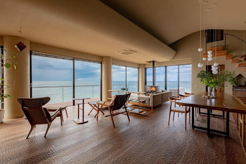 a dining room with a view of the ocean at TORIKKA Stay -ビーチに建つ貸別荘- in Sumoto