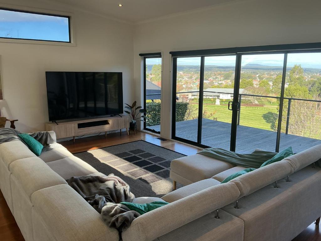 a living room with a large couch and a flat screen tv at Black Hill Retreat, Ballarat in Nerrina