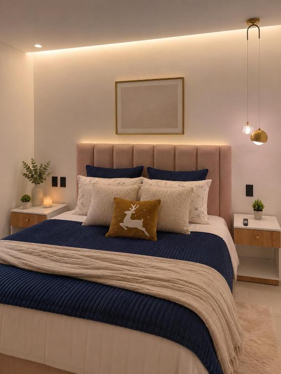 a bedroom with a large bed with blue sheets and pillows at Suite de Lujo la Carolina in Quito