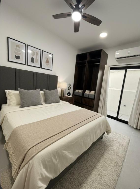 a bedroom with a large bed with a ceiling fan at Estancia Moderna y cerca del Malecon de La Paz in La Paz