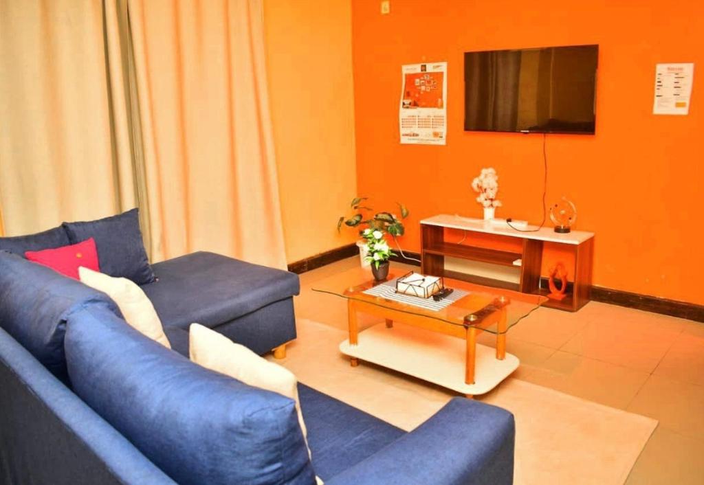 a living room with a blue couch and a table at Hecahomes in Kericho