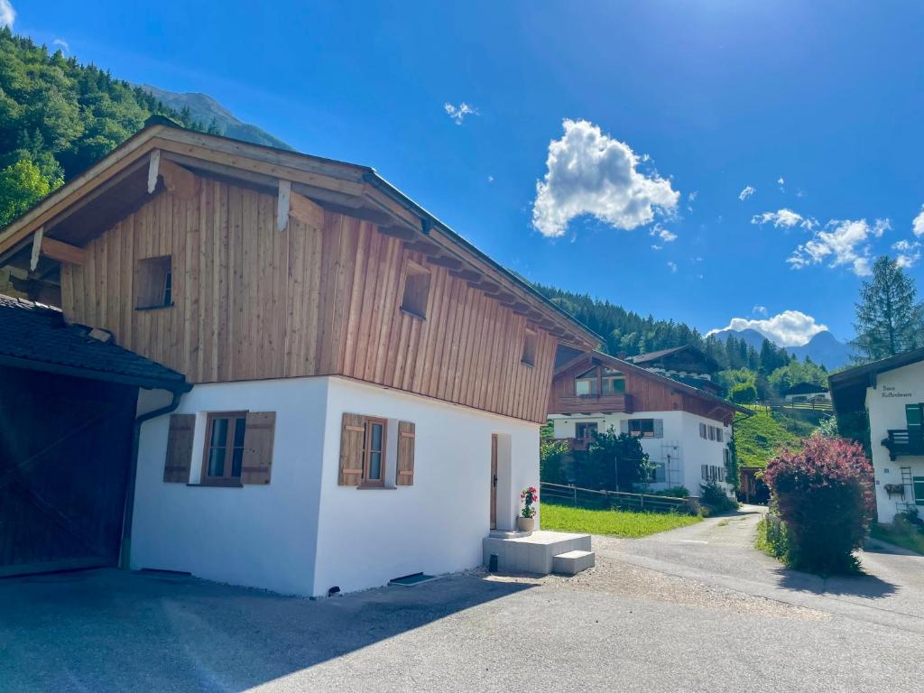a house with a wooden roof and a garage at Chalet Kogelleiten in Ramsau