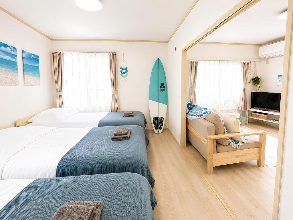 a bedroom with two beds and a surfboard in it at Shonan Beach&Sun in Chigasaki