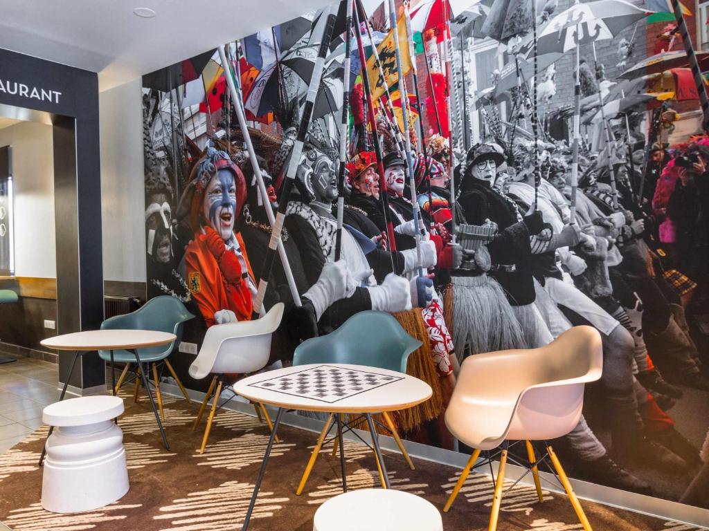 a mural in a restaurant with chairs and tables at ibis Dunkerque in Dunkerque